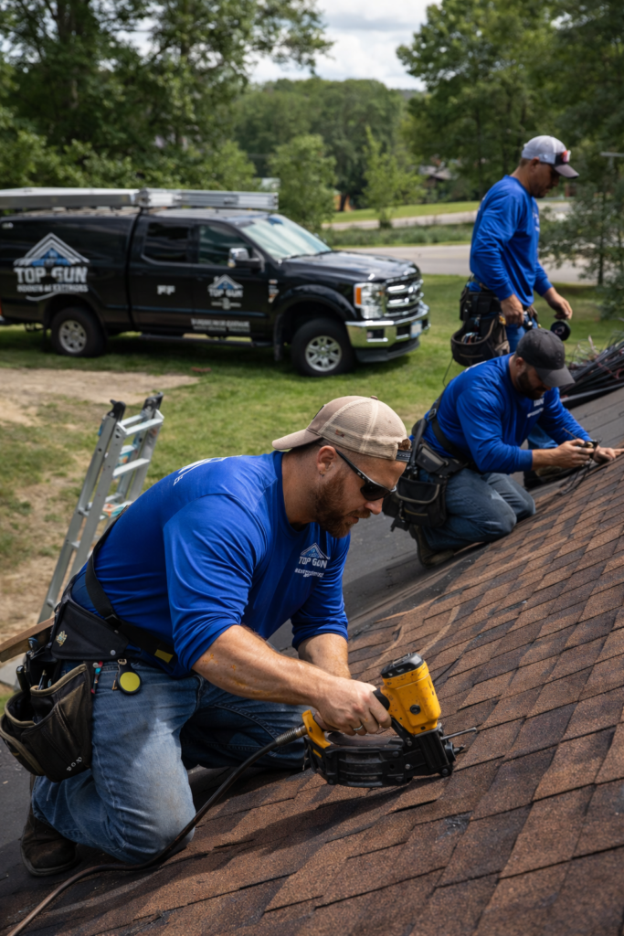 Top Gun Roofing & Exteriors team installing asphalt shingles on a residential roof in West Michigan